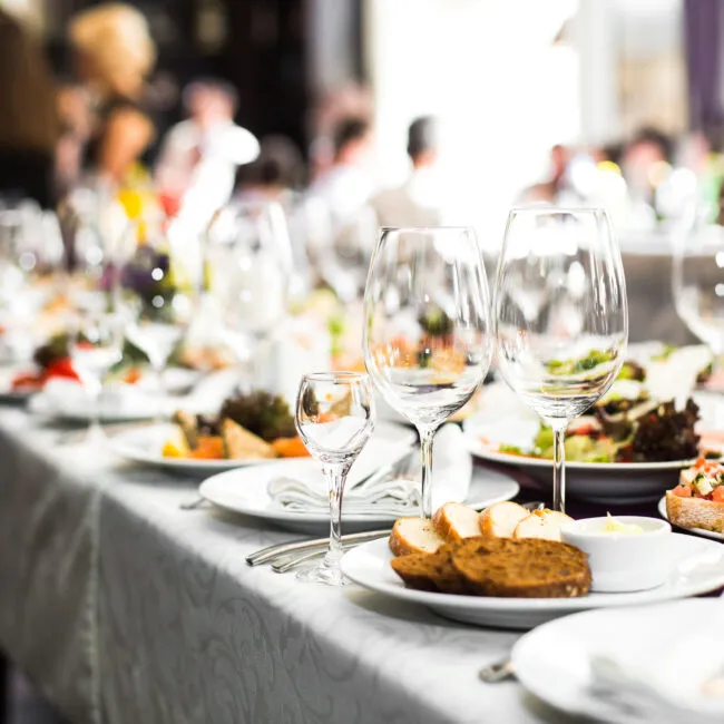 An elegant long table set for a catered wedding dinner by The Cook & The Drummer